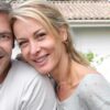 Couple heureux assis devant leur nouvelle maison
